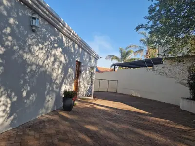 a white building with a potted plant on the side at Amen guest apartment in Pretoria