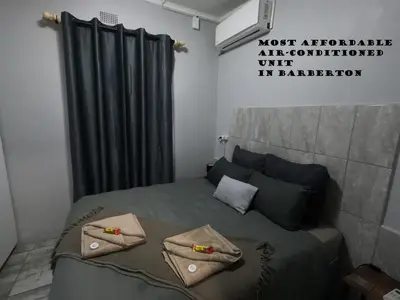 a bedroom with a bed with two pillows on it at Makhonjwa Rose Barberton in Barberton