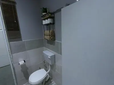 a bathroom with a white toilet in a room at Makhonjwa Rose Barberton in Barberton