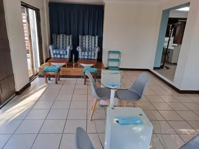 a lobby with chairs and a table in a building at Sentinel Condo in Pretoria