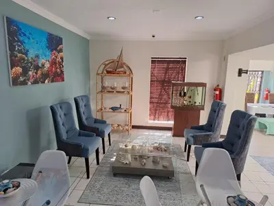 a living room with blue chairs and a table at Sentinel Condo in Pretoria