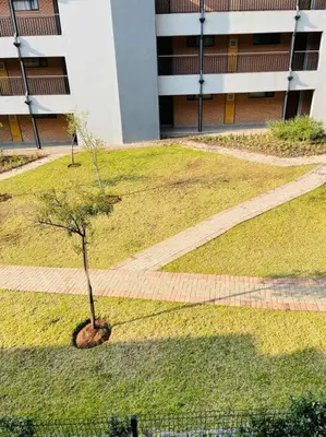a tree in the middle of a field of grass at Waterfall Ridge Premium Apartments in Midrand