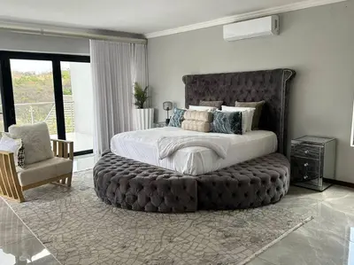 a bedroom with a large bed with a large ottoman at LaRo in Boschrand