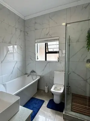 a bathroom with a tub and a toilet and a shower at LaRo in Boschrand