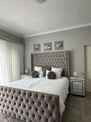a bedroom with a large bed with a large headboard at LaRo in Boschrand