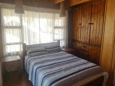 a bed in a room with a window at Wooden Log House in Bela-Bela