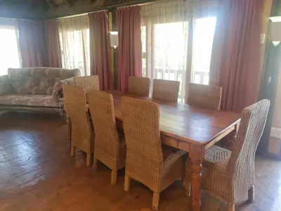 a dining room with a wooden table and chairs at Wooden Log House in Bela-Bela