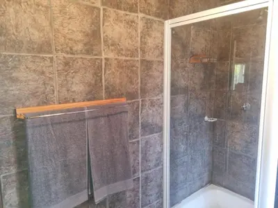 a bathroom with a shower with a shower curtain at Wooden Log House in Bela-Bela