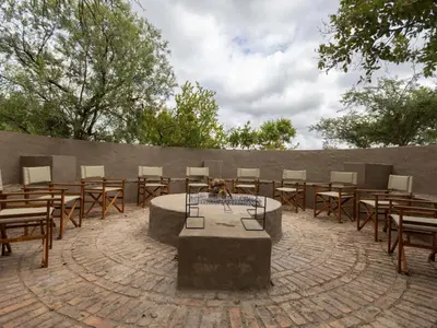 a group of tables and chairs in a courtyard at Amy's Camp at the Kevin Richardson Foundation in Dinokeng Game Reserve