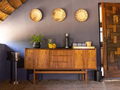 a wooden cabinet in a room with plates on the wall at Amy's Camp at the Kevin Richardson Foundation in Dinokeng Game Reserve