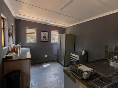 a kitchen with a refrigerator and a counter top at Amy's Camp at the Kevin Richardson Foundation in Dinokeng Game Reserve