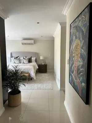 a bedroom with a bed and a painting on the wall at Luxury Escape - Pecanwood Golf Estate - Hartbeespoort in Hartbeespoort