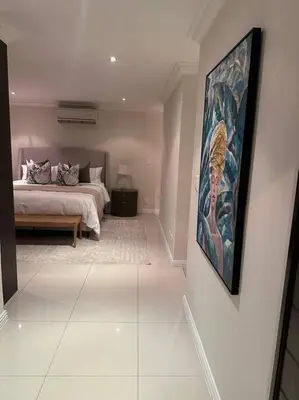a bedroom with a bed and a painting on the wall at Luxury Escape - Pecanwood Golf Estate - Hartbeespoort in Hartbeespoort