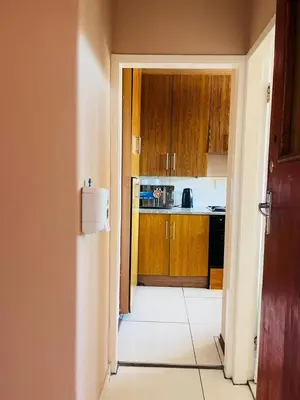 an open door to a kitchen with wooden cabinets at Palm Rest in Pretoria