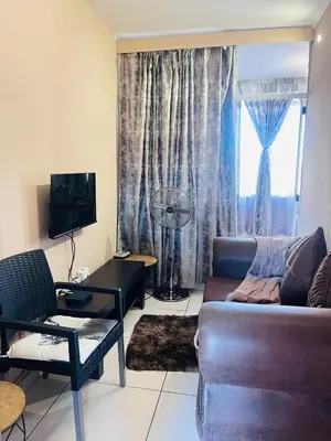 a living room with a couch and a table at Palm Rest in Pretoria