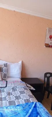 a bedroom with a bed and a table with a picture at Masha accomodation in Jane Furse