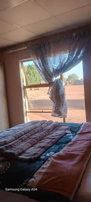 a bed in a room with a window at Masha accomodation in Jane Furse