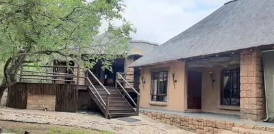 a house with a staircase on the side of it at Assegai Lodge in Moheme
