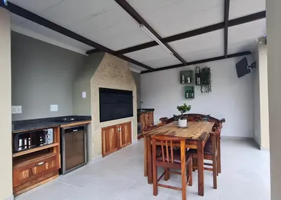 a large kitchen with a wooden table and a tv at Upstairs R-1 Self-Catering Unit in White River