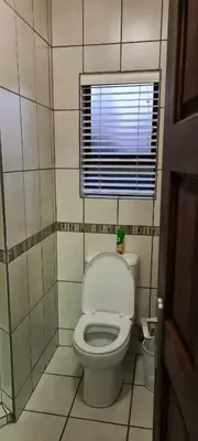 a small bathroom with a toilet and a window at Upstairs R-1 Self-Catering Unit in White River