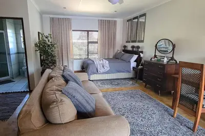 a living room with a couch and a bed at Upstairs R-1 Self-Catering Unit in White River