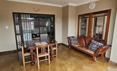 a living room with a couch and a table and chairs at Upstairs R-1 Self-Catering Unit in White River
