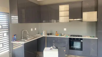a kitchen with black cabinets and a sink and a stove at Zinnia house in Midrand
