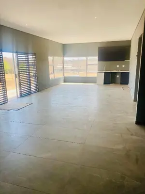 an empty room with a large room with large windows at Zinnia house in Midrand