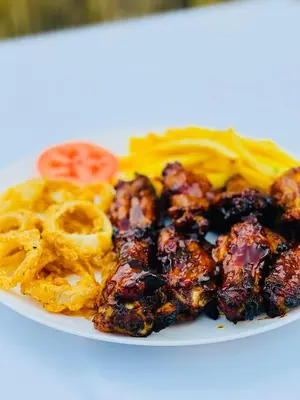 a plate of food with chicken wings and waffle fries at Debreeze guest lodge in Malelane