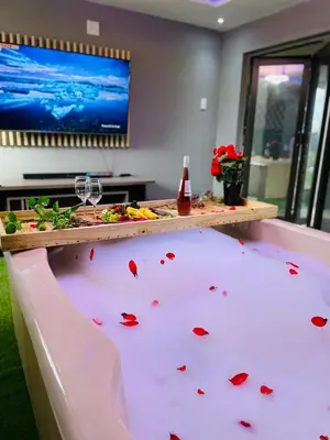 a bath tub filled with red flower petals at Debreeze guest lodge in Malelane