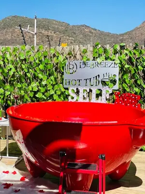 a red bath tub sitting in front of a hedge at Debreeze guest lodge in Malelane