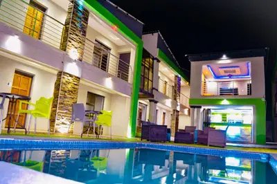 a swimming pool in front of a building at night at Debreeze guest lodge in Malelane