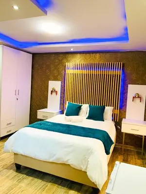 a bedroom with a large bed and two night stands at Debreeze guest lodge in Malelane