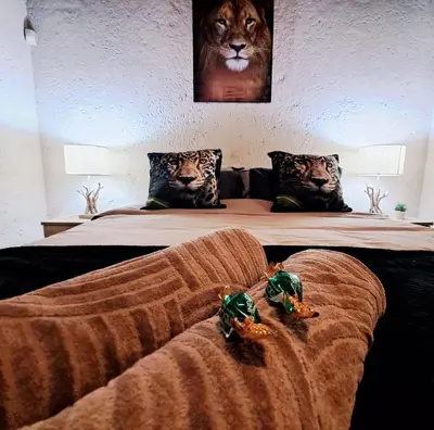 a bed with a blanket and two stuffed animals on it at Erdvark Bosbreek in Marloth Park