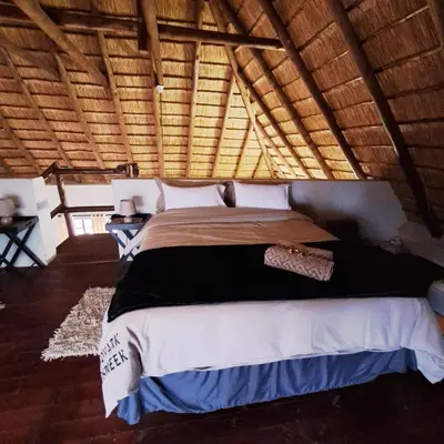 a bedroom with a large bed in a room at Erdvark Bosbreek in Marloth Park