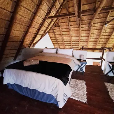 a bedroom with a large bed in a room at Erdvark Bosbreek in Marloth Park