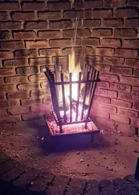 a fireplace with a fire in a brick wall at Erdvark Bosbreek in Marloth Park