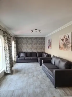a living room with couches and a couch at Airport Lodge OR Tambo in Kempton Park