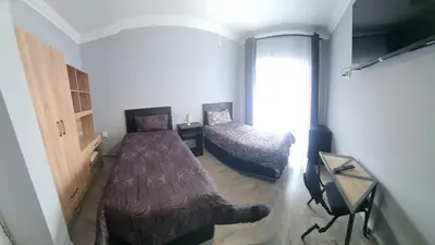a bedroom with a bed and a table and a window at Airport Lodge OR Tambo in Kempton Park