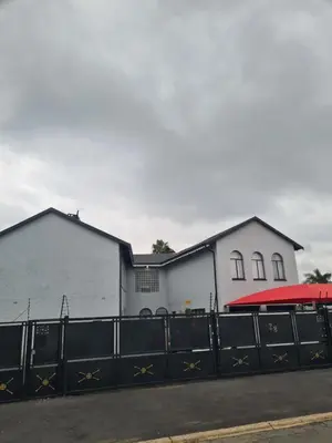 a white building with a fence in front of it at Airport Lodge OR Tambo in Kempton Park