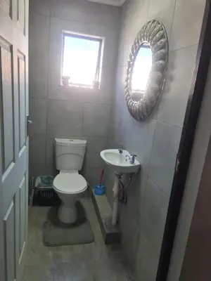 a bathroom with a toilet and a sink and a mirror at Airport Lodge OR Tambo in Kempton Park