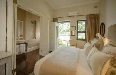 a large white bedroom with a bed and a sink at Torburnlea Homestead Luxury Accommodation in Nelspruit