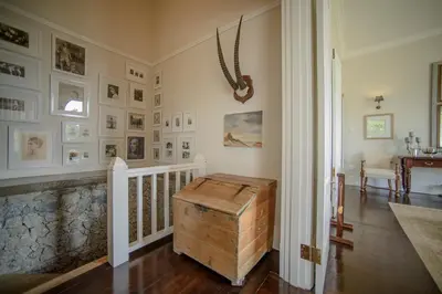 a room with a staircase with pictures on the walls at Torburnlea Homestead Luxury Accommodation in Nelspruit