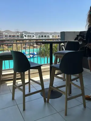 a table and chairs on a balcony with a pool at The Blyde Penthouse in Pretoria