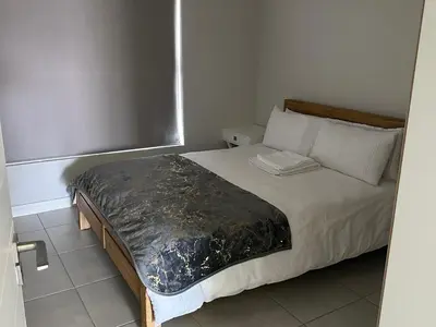 a bedroom with a large bed with white pillows at The Blyde Penthouse in Pretoria
