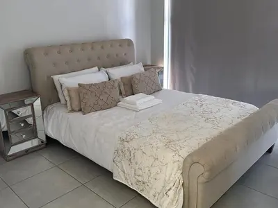 a bedroom with a large bed with a large headboard at The Blyde Penthouse in Pretoria