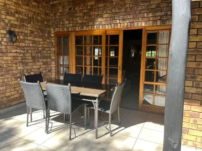 a wooden table and chairs on a patio at Kruger Park Lodge, Mpumalanga Unit 424 in Hazyview