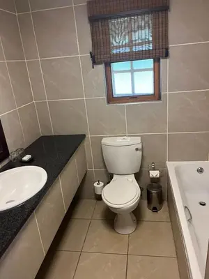 a bathroom with a toilet and a sink and a tub at Kruger Park Lodge, Mpumalanga Unit 424 in Hazyview