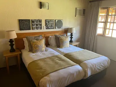 a bedroom with two beds with pillows and a window at Kruger Park Lodge, Mpumalanga Unit 424 in Hazyview