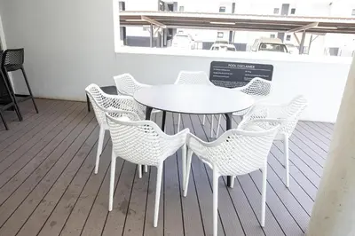 a white table and chairs in a room at Waterkloof on Main Sassy Modern Apartment in Pretoria